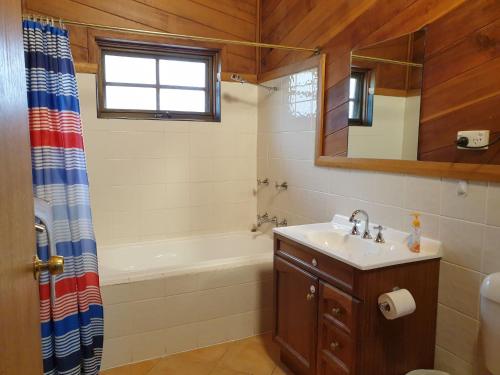 a bathroom with a sink and a tub and a shower at Beulah by the Lake in Kalkite