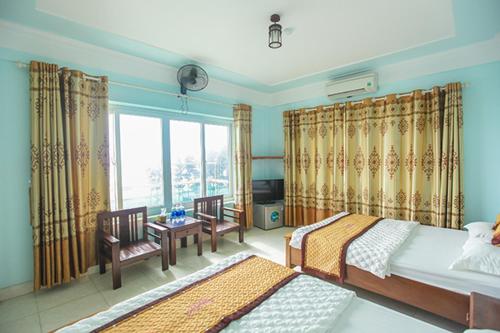a bedroom with two beds and a window at Thành Thư Vân Đồn Hotel - by Bay Luxury in Quang Ninh