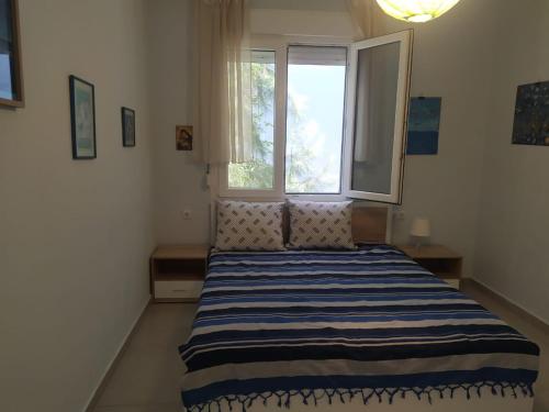 ポトスにあるFamily house by the beachのベッドルーム1室(青と白のストライプのベッド1台、窓付)