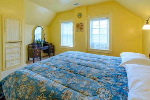 a bedroom with a bed and a dresser and windows at Panguich Red Brick Homes upper Home in Panguitch