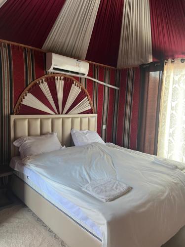 a bed in a room with a striped wall at RUM iSLAND LUXURY CAMP in Wadi Rum