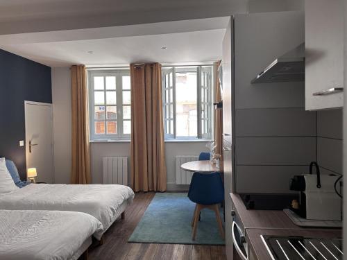 a bedroom with a bed and a table and window at Charmant Studio en Centre Historique avec Terrasse Privée et Tout Confort - FR-1-489-460 in Moulins