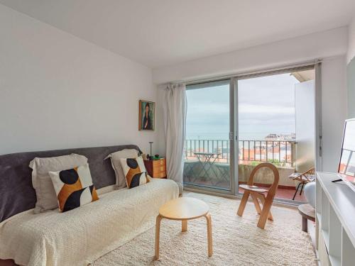 un salon avec un canapé et une grande fenêtre dans l'établissement Studio près de la plage aux Halles, Biarritz - FR-1-3-591, à Biarritz