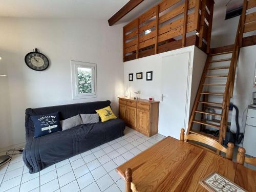 un salon avec un canapé et un escalier en colimaçon dans l'établissement Maison à 300m de la plage avec terrasse, 5 couchages, parking privé - Saint-Hilaire-de-Riez - FR-1-224C-256, à Saint-Hilaire-de-Riez