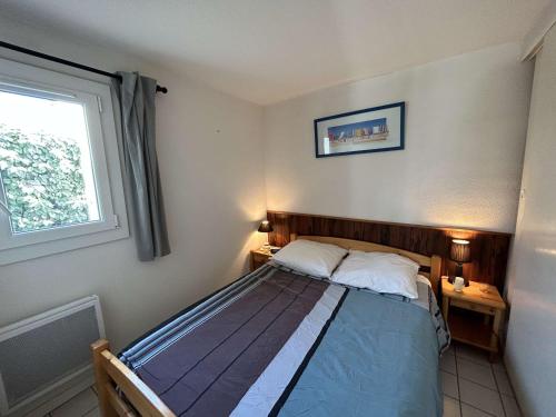 - une chambre avec un lit avec deux oreillers et une fenêtre dans l'établissement Maison à 300m de la plage avec terrasse, 5 couchages, parking privé - Saint-Hilaire-de-Riez - FR-1-224C-256, à Saint-Hilaire-de-Riez