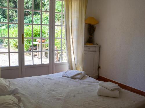une chambre avec un lit et une grande fenêtre dans l'établissement Charmante Maison Provençale avec Piscine et Oliveraie à Trans-en-Provence - FR-1-728-11, à Trans-en-Provence