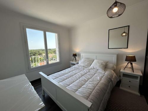 une chambre avec un lit blanc et une grande fenêtre dans l'établissement Appartement 2 pièces avec parking à Saint-Jean-de-Monts - FR-1-224C-257, à Saint-Jean-de-Monts