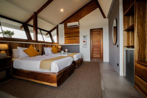 a bedroom with two beds in a room at Surf Synergy All-Inclusive Surf and Wellness Retreat in Jacó