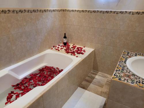 a bathroom with a bath tub filled with red roses at Casa Miranda in Antigua Guatemala