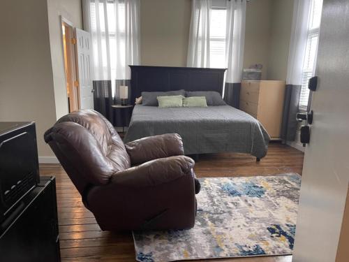 a bedroom with a bed and a leather chair at Suite2-1King Bed1Bath-1BlockFromMercerHospitals in Macon