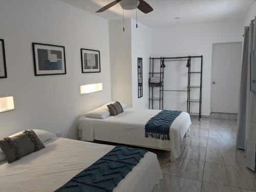 a bedroom with two beds and a ceiling fan at Hermoso departamento en Cancún YaxBahia 3 in Cancún