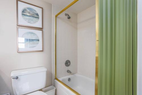 ein Badezimmer mit einem grünen Duschvorhang und einem WC in der Unterkunft San Marco Gulf Beach Views 3rd Floor in Venice