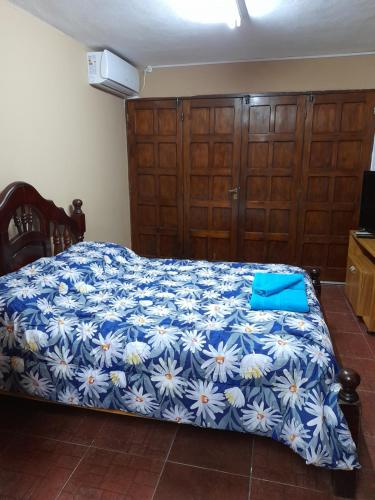 um quarto com uma cama azul e branca com armários de madeira em Valentino Apart II em Jesús María