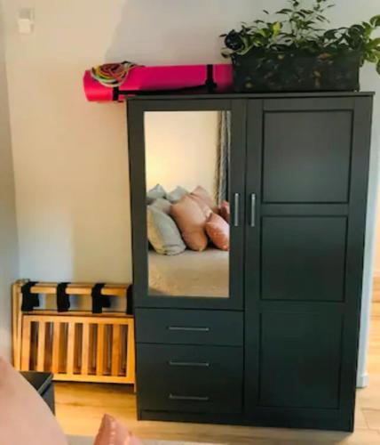 a black cabinet with a mirror in a room at Red Rock Escape - Cozy King Bed Studio & Gardens, Trails, Views, Red Rock Pass in Sedona