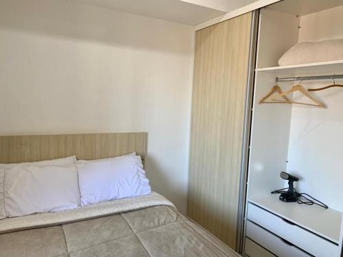 Dormitorio pequeño con cama y armario en Studio flat Mid Home, en Curitiba