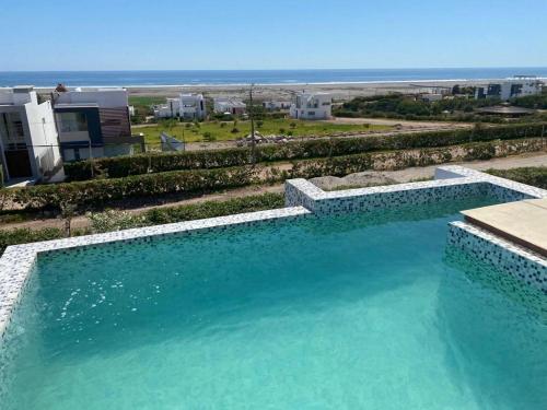 una gran piscina con vistas al océano en G&E_BEACH HOUSE, en Mejia