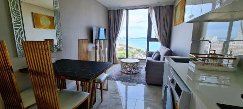a kitchen with a table and a view of the ocean at Pattaya Seaview Beachfront Skypool Copacabana Jomtien Condo in Jomtien Beach