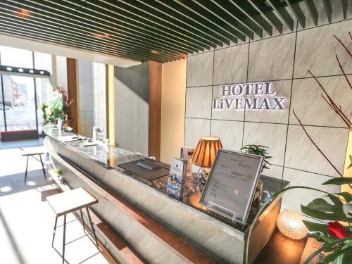 a hotel lobby with a counter with a laptop on it at HOTEL LiVEMAX Sapporo Susukino in Sapporo