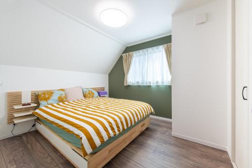 a bedroom with a bed with a striped comforter at Ici Japon Village in Tokyo