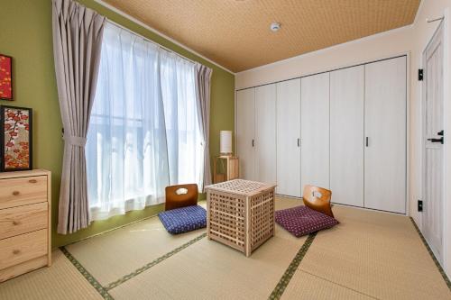 a room with a table and two chairs and a window at Ici Japon Village in Tokyo