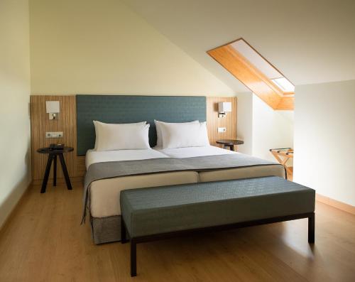 a bedroom with a large bed with a green headboard at Pousada A Lanzada in A Lanzada