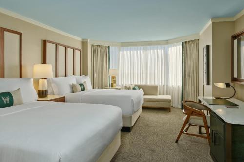 a hotel room with two beds and a desk at The Whitley, a Luxury Collection Hotel, Atlanta Buckhead in Atlanta