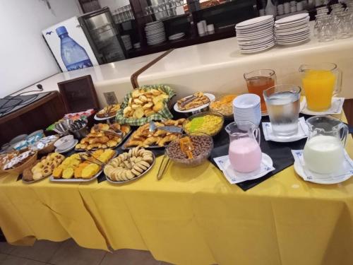 a table full of food on a yellow table at Gran Hotel Augusto in Mar del Plata