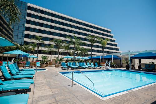 a pool with blue lounge chairs and a building at Renaissance Newport Beach Hotel in Newport Beach