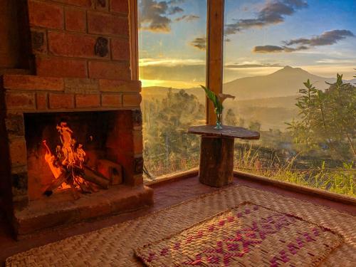 a fireplace in a room with a view of the mountains at Cabañas y Glampings Balcon del lago in Otavalo