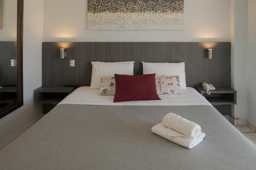 1 dormitorio con 1 cama blanca grande con almohadas rojas en Red Hotel Centric Santiago, en Santiago
