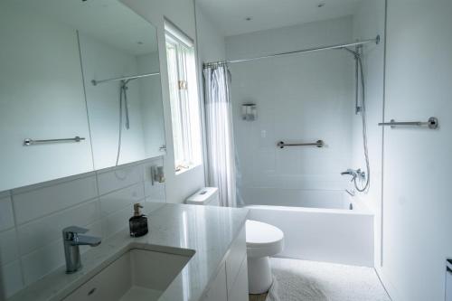 a white bathroom with a sink and a shower at Le Rétro Chic à Mont-Tremblant in Mont-Tremblant