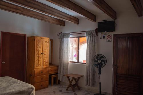 Un dormitorio con una cama y una ventana y un televisor. en Hotel El Patio, en Tequisquiapan