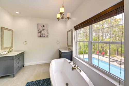 uma casa de banho com banheira e uma grande janela em Pet-Friendly Southampton Paradise with Pool! em Southampton