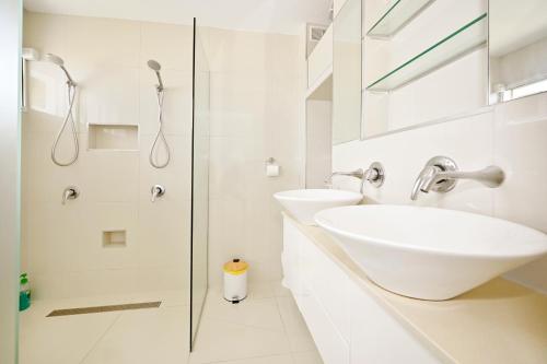 a white bathroom with a sink and a shower at Alexandra Headland Ocean Dream - Stunning View ZA6 in Alexandra Headland