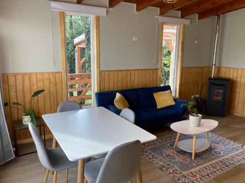 a living room with a white table and a blue couch at El Viloche - Tiny House in Puerto Montt