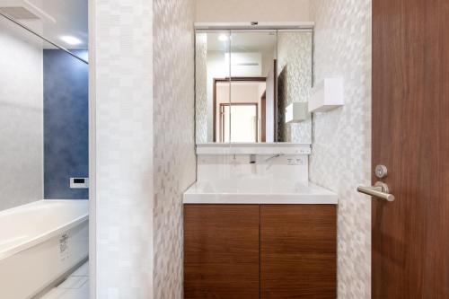 W łazience znajduje się umywalka i lustro. w obiekcie Ici Japon Village w Tokio