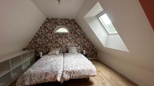 una camera da letto con letto in mansarda di Maison de campagne a Vuillafans