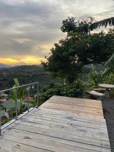 een houten terras met een bank op een heuvel bij Casa Vista Cafe in Cartago