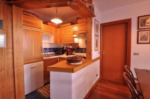 a kitchen with wooden cabinets and a counter top at Casa Colmet - Bilocale Spazioso La Thuile in La Thuile