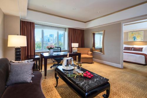 um quarto de hotel com uma sala de estar com uma cama em The St. Regis Beijing em Pequim