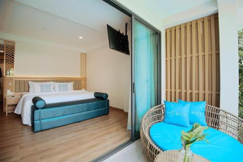 a bedroom with a bed and a couch and a chair at Infinity Aonang Krabi in Ao Nang Beach