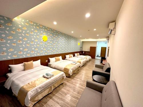 una habitación de hotel con 4 camas y una pared con un mural en Sun Moon Lake Dream House B&B, en Yuchi