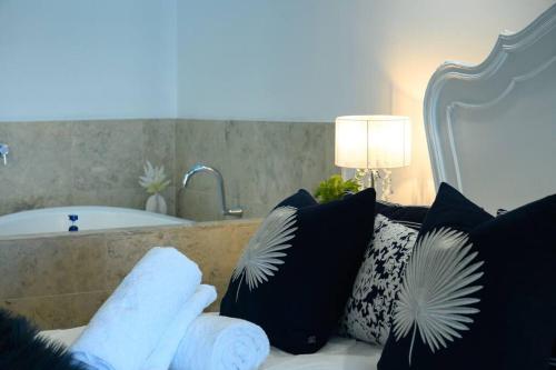 a room with a couch with pillows and a bath tub at Villa by the Sea in Mandurah