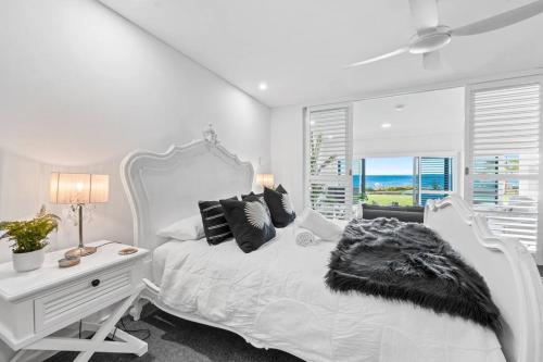 Villa by the Sea في ماندورا: غرفة نوم بيضاء مع سرير أبيض ومكتب
