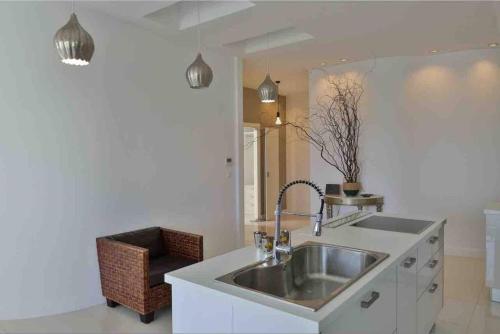 a kitchen with a sink and a chair at Beach Apartment with Seaview II in Olympic Beach