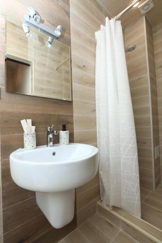 La salle de bains est pourvue d'un lavabo blanc et d'un miroir. dans l'établissement Syune Mini Hotel, à Gyumri