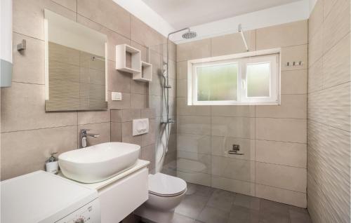 a bathroom with a sink and a toilet and a window at Stunning Home In Jadranovo With 4 Bedrooms, Wifi And Outdoor Swimming Pool in Jadranovo