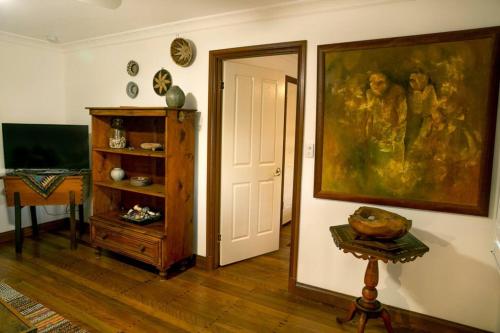 a living room with a painting on the wall at Quaint, Charming Pumicestone Cottage - Beach Charm - ZA7 in Golden Beach