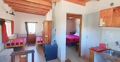 a room with a kitchen and a room with a bed at Fincachica in Cachí