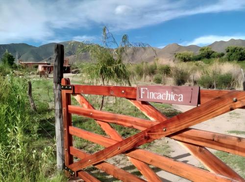 une clôture en bois munie d'un panneau. dans l'établissement Fincachica, à Cachí